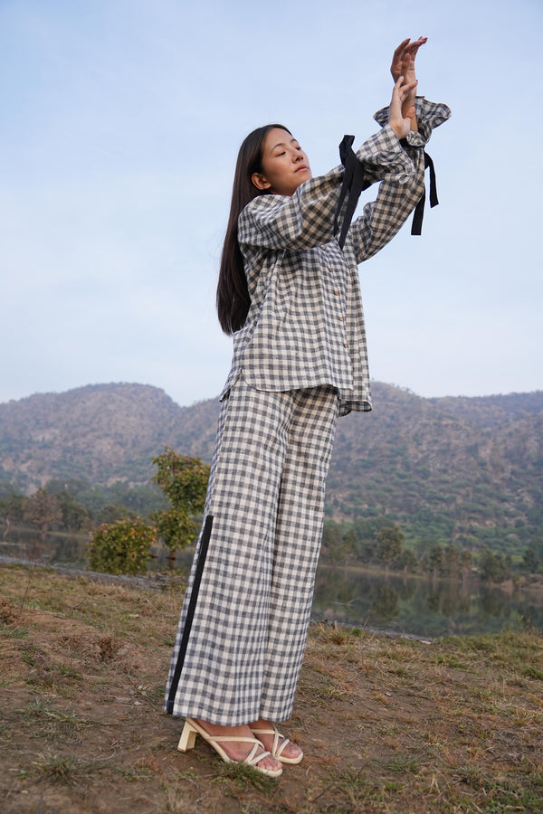 Woman wearing the Sutra Balloon Sleeve Check co-ord — a checked cotton top with balloon sleeves and wide-leg pants