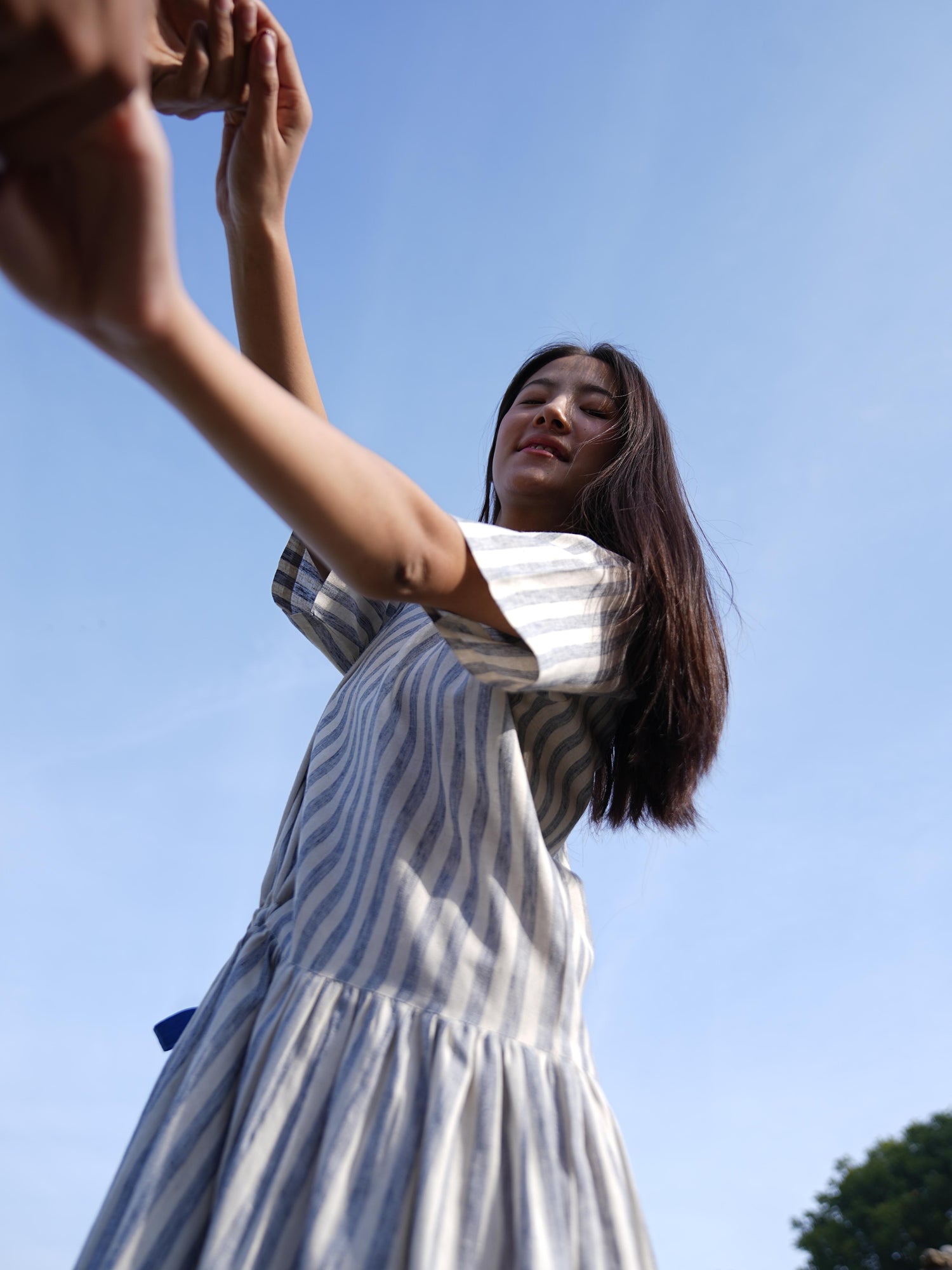 Relaxed, anti-fit striped cotton dress shown in natural daylight