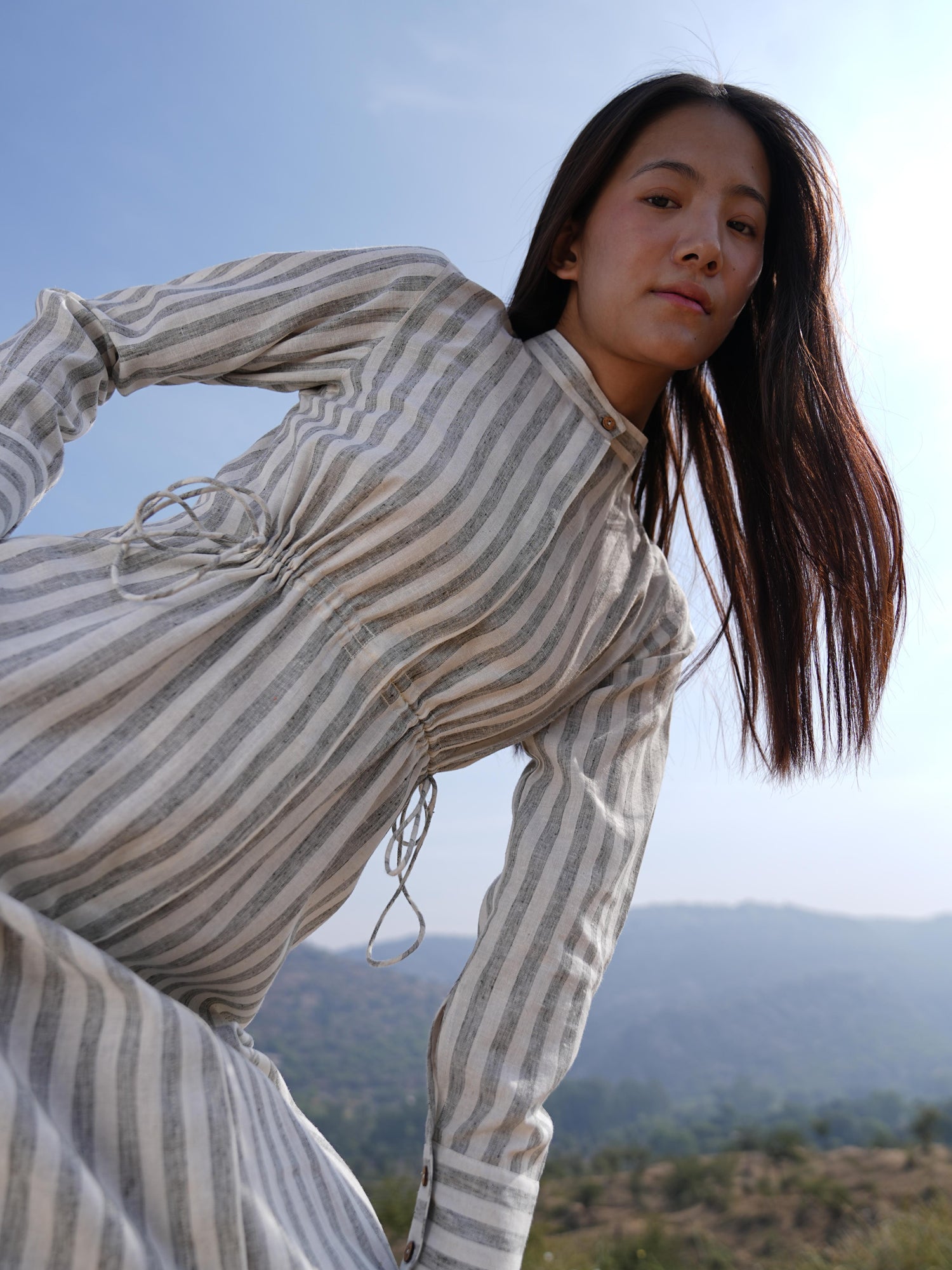 Woman wearing the Sutra Stripe Maxi Dress — a full-length striped cotton dress with a high neck and long sleeves