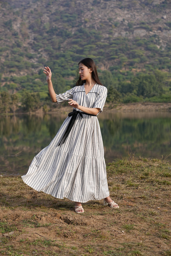 Woman wearing the Sutra Midi Stripe Dress — a striped cotton midi dress with a tiered, flared skirt