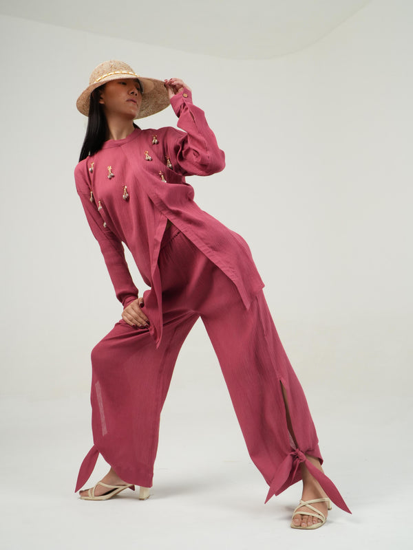 Woman wearing the Vanshitaaz Fruit Dove crinkled cotton co-ord — an embellished high-low top with side slit and tie-up trousers