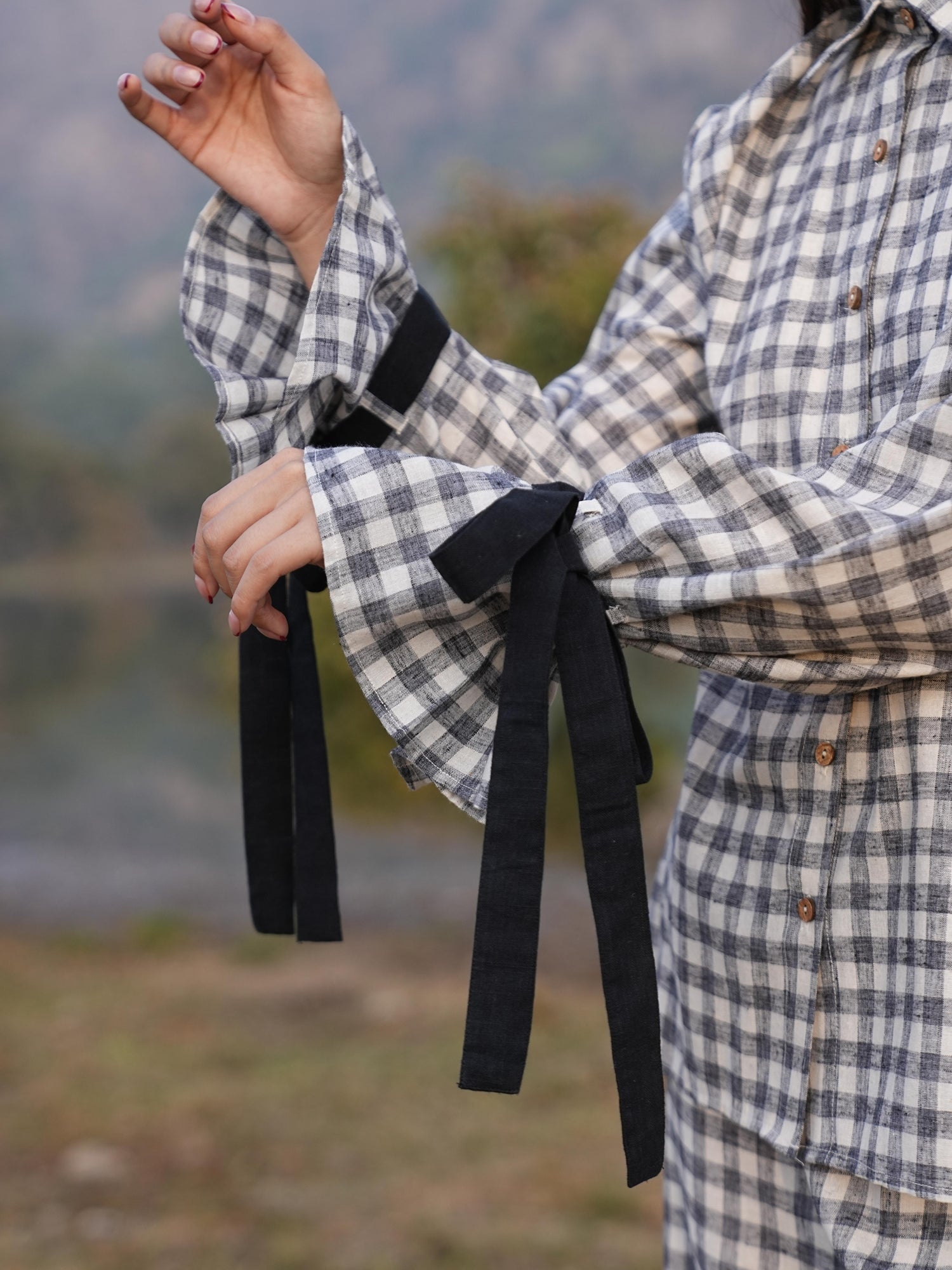 Contrast black tie-up detailing at the balloon-sleeve cuffs