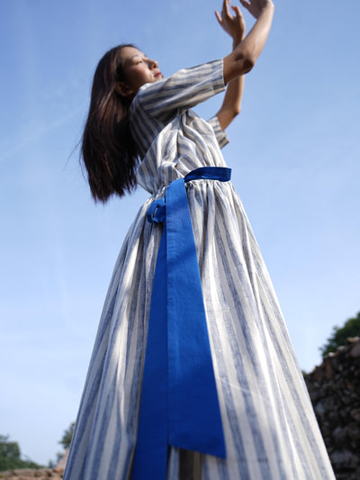 Woman wearing the Sutra Stripe Dress with Button Back — a flowing striped cotton dress with a round neck