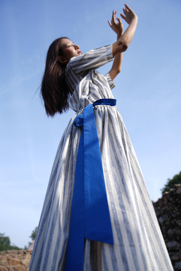 Woman wearing the Sutra Stripe Dress with Button Back — a flowing striped cotton dress with a round neck