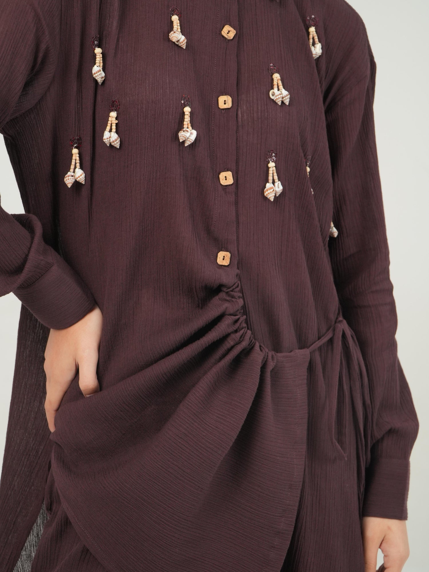Wrap-style detail of the deep burgundy crinkled cotton top