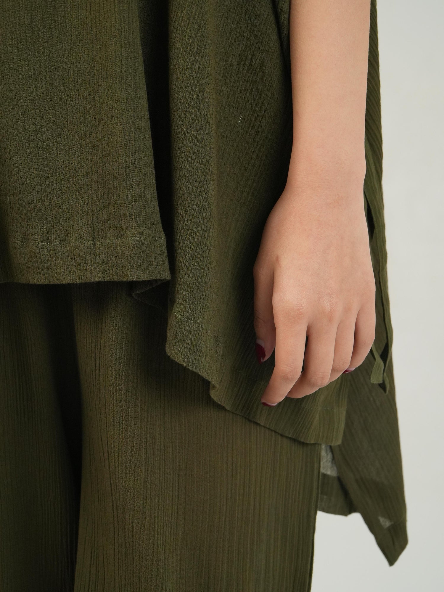 Close-up of the crinkled cotton texture and subtle embellishment