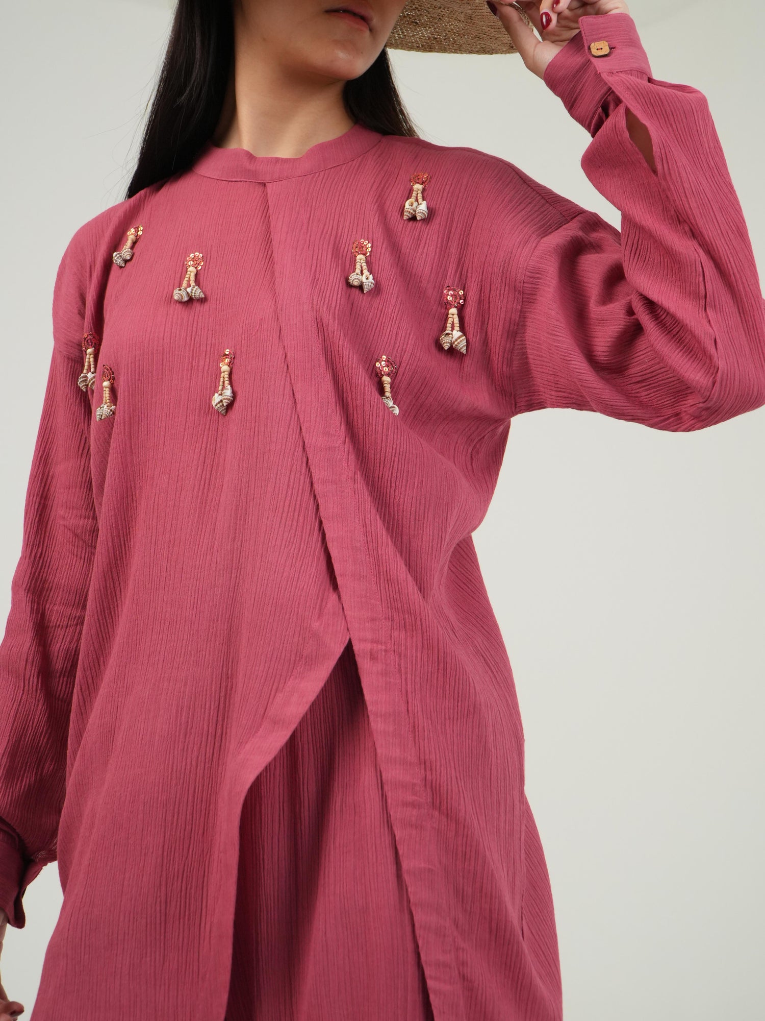 Side-slit and high-low hemline detail of the crinkled cotton top